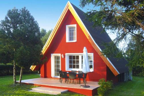 ein rotes Haus mit einem Tisch und Stühlen davor in der Unterkunft Ferienhaus Chrissi in Quilitz