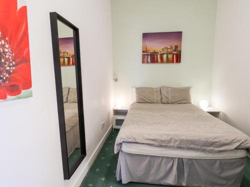 a small bedroom with a bed and a mirror at 6 Beach View Beaconsfield House in Bridlington