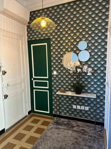 Cette chambre dispose d'une porte verte et d'un miroir. dans l'établissement Typique 3 fenêtres marseillais, à Marseille