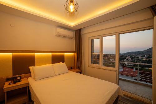 a bedroom with a bed and a window with a view at Estia Hotel in Gokceada Town