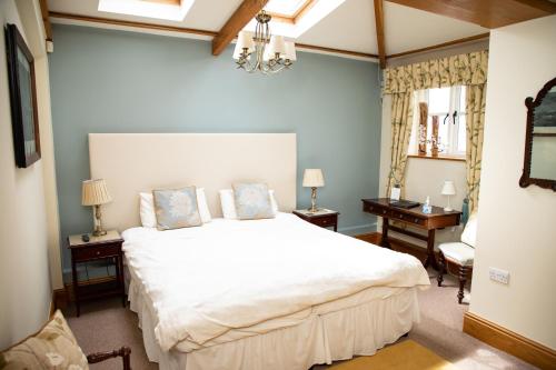 a bedroom with a large white bed in a room at Mere Brook House in Wirral