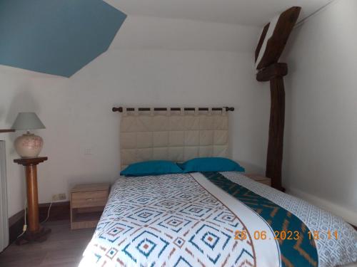 a bedroom with a large bed with a wooden headboard at La Bergeronnette 