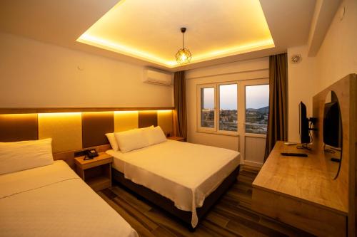 a hotel room with two beds and a television at Estia Konukevi in Gokceada Town