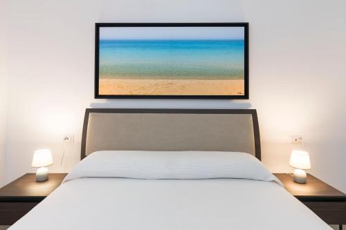 a bedroom with a bed with a picture of the beach at DipintodiBlu Charming House in Lampedusa