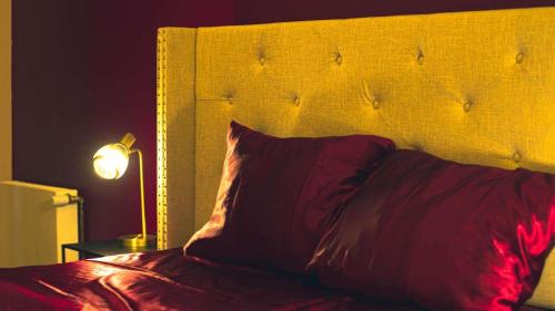 a bed with a red pillow and a lamp at Escapade Urbaine - Balnéothérapie - Cinéma au Cœur de la Ville in Mâcon
