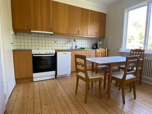 cocina con mesa, mesa y sillas en Stor etta på lugna söder en Växjö