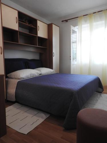 a bedroom with a large bed and a window at Apartman David in Barbat na Rabu