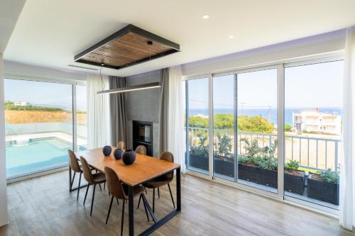 a dining room with a table and chairs and windows at 4C Rethymno in Skaleta