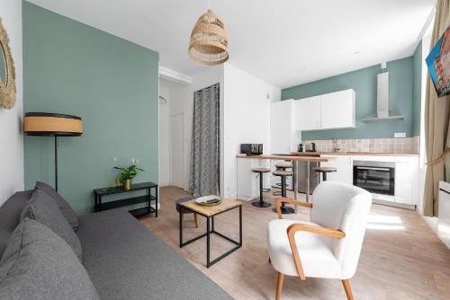 un salon avec un canapé et une cuisine dans l'établissement Le Stalingrad - T2 Moderne - à 2 pas de la Gare, à Toulouse