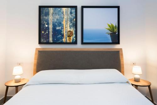a bedroom with a bed and two pictures on the wall at DipintodiBlu Charming House in Lampedusa