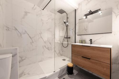 une salle de bain blanche avec une douche et un lavabo dans l'établissement Le Stalingrad - T2 Moderne - à 2 pas de la Gare, à Toulouse