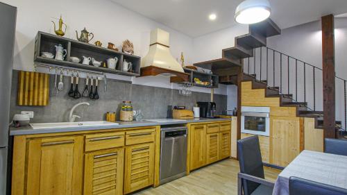 a kitchen with wooden cabinets and a spiral staircase at RunCa-n Rai in Cristian