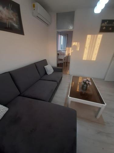 - un salon avec un canapé noir et une table basse dans l'établissement Apartman Vukoja - Posušje, à Posušje