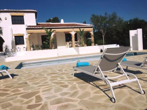 a pair of chairs sitting next to a swimming pool at La Finca Blanca Javea in El Tosalet