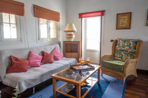 a living room with a couch and a table and a chair at Villa Mirador Los Hoyos in Las Palmas de Gran Canaria