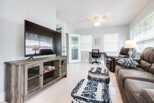 a living room with a couch and a flat screen tv at Murray Dale Hideaway in Valrico