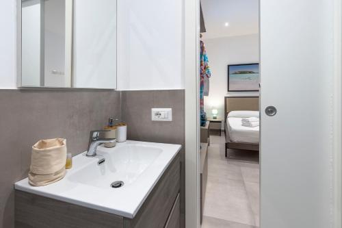 a bathroom with a white sink and a bedroom at DipintodiBlu Charming House in Lampedusa