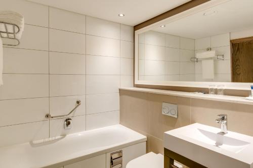 a bathroom with a sink and a mirror at Protea Hotel by Marriott Durban Umhlanga in Durban