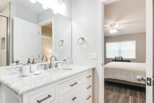 a white bathroom with a sink and a bed at Murray Dale Hideaway in Valrico