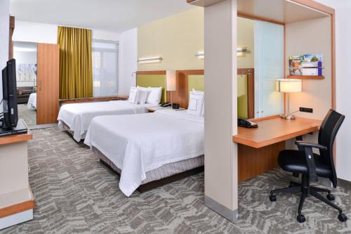 a hotel room with two beds and a desk at Springhill Suites by Marriott Detroit Metro Airport Romulus in Romulus