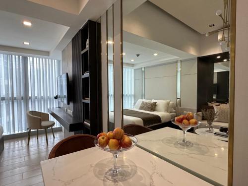 a kitchen and living room with a table with fruit on it at Uptown Parksuites BGC in Manila