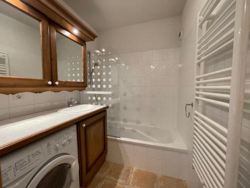 een badkamer met een wasmachine en een bad bij Appartement Samoëns, 2 pièces, 4 personnes - FR-1-624-88 in Samoëns