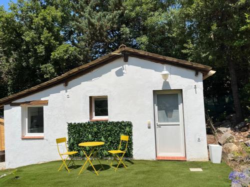 uma pequena casa branca com uma mesa e cadeiras em Un Studio dans un endroit tranquille em Roquefort Les Pins