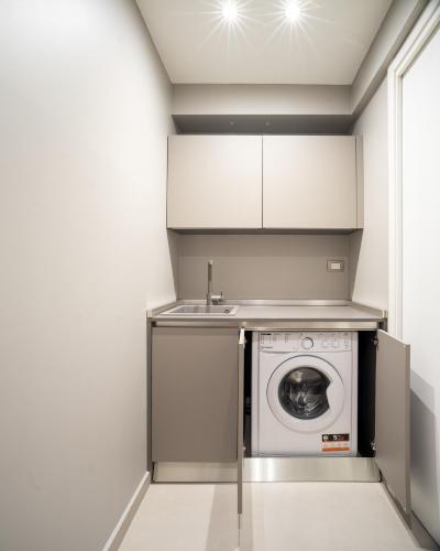 a kitchen with a washing machine and a sink at Palazzo Del Carretto-Art Apartments and Guesthouse in Turin