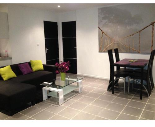 ein Wohnzimmer mit einem Sofa und einem Tisch in der Unterkunft Hollidays home piscine et jardin in Plan-de-Cuques