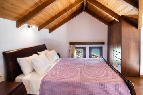 a bedroom with a large bed with a wooden ceiling at Sunrise Vista by Vintage Travel in Vasiliki