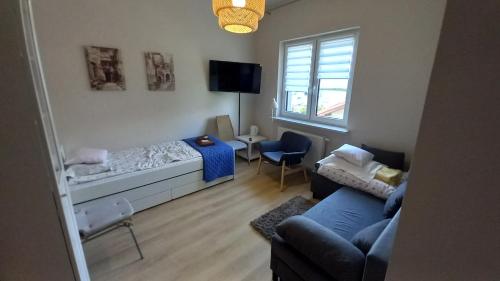 una pequeña sala de estar con cama y sofá en Pokoje gościnne Sandomierz, en Sandomierz