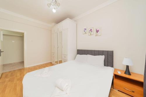 Biała sypialnia z dużym łóżkiem i biurkiem w obiekcie Chic Flat w Balcony 3 min to Beach in Antalya w mieście Antalya