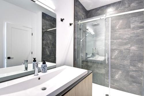 a bathroom with a sink and a shower at 101 Verbier - New 3BR Lux Condo w Mtn View Close to Everything in Mont-Tremblant