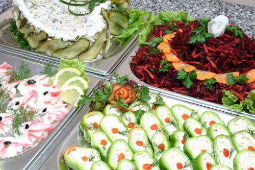 un buffet de diferentes tipos de comida en bandejas en Ljuljak Hotel, en Golden Sands