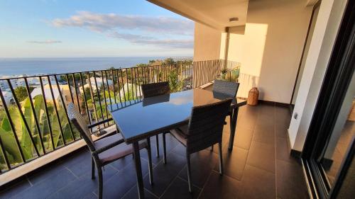 a balcony with a table and chairs and the ocean at Le Panorama in Fleurimont