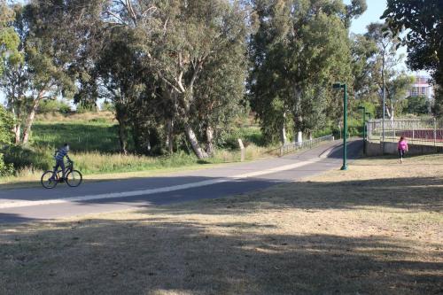 a person riding a bike down a road at Rosen Villa at Ramat Hahayal in Tel Aviv