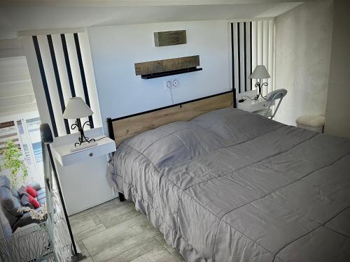 1 dormitorio con 1 cama, 2 mesas y 2 lámparas en Naturiste Heliovillage Villa de Standing, en Cap d'Agde