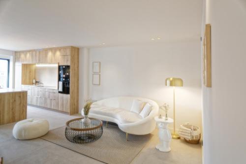a living room with a white couch and a table at Les Terrasses de Sainte Waudru in Mons