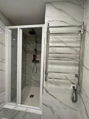 a shower with a glass door in a bathroom at Parkside Escape: Stylish 1-BR in Rīga