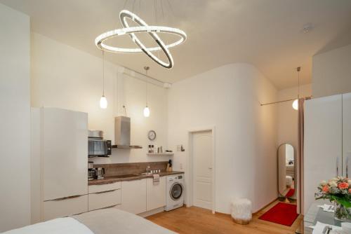 a kitchen with white cabinets and a chandelier at Comfort Apartment Baden-Baden in Baden-Baden