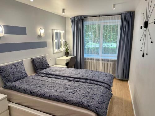 a bedroom with a large bed and a window at Parkside Escape: Stylish 1-BR in Rīga