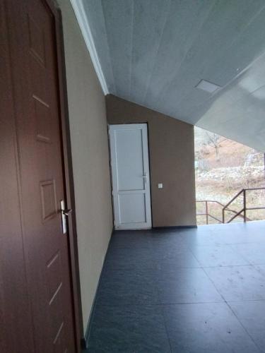 um quarto vazio com uma porta e um corredor em Lika's Sweet House em Katsʼkhi