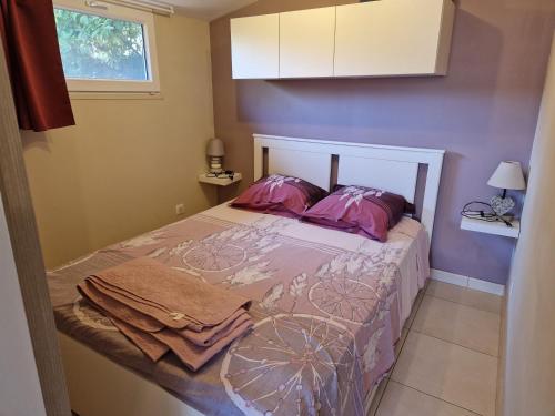 - une chambre avec un lit aux murs violets dans l'établissement Chalet de 25 m2 avec jardin, piscine et spa uniquement accessible en juin sept, à Lorgues