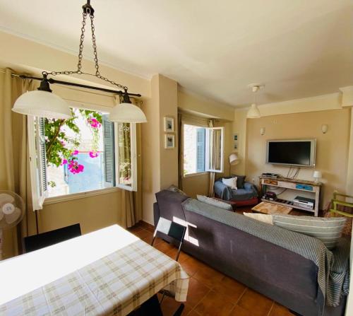 a living room with a couch and a tv at ISLAND HOUSE in Poros