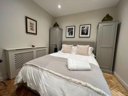 a bedroom with a large bed with white sheets and pillows at Luxury London English Charm in London