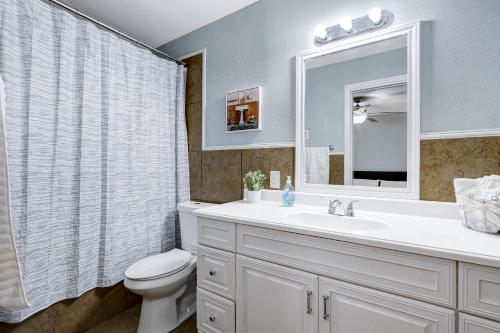 a bathroom with a sink and a toilet and a mirror at King Bed Lovely Escape Mins To Seaworld Pool in San Antonio
