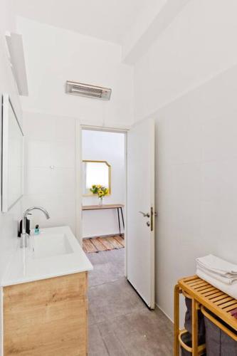 a white kitchen with a sink and a table at Designed 2BR apartment over Dizengoff square - Panoramic View in Tel Aviv