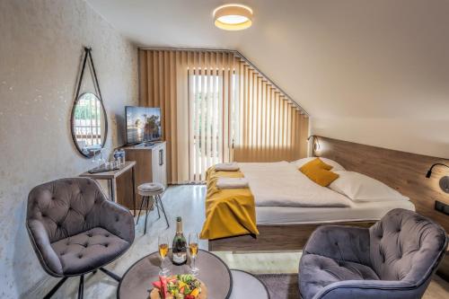 Hotel Beta في بزينيتس: غرفة نوم بسرير وكرسيين وطاولة
