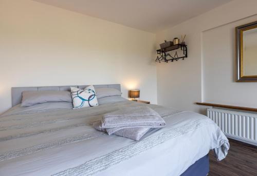 a bedroom with a large white bed with pillows at Causeway Coast Retreats in Dervock