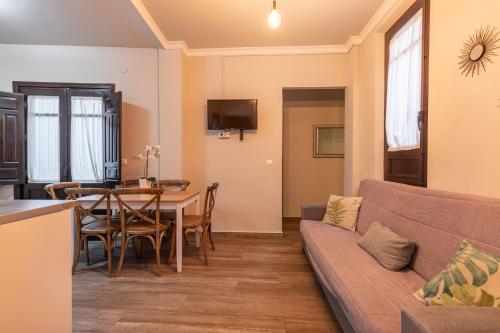 a living room with a couch and a table at Apartamentos Alhambra Granada 3000 in Granada